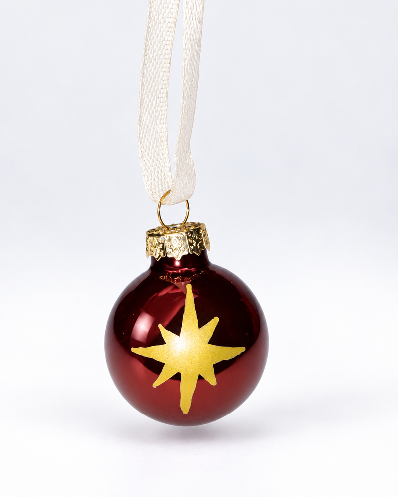 Handmade glossy dark brown glass Christmas ornament with gold polar star design and cream ribbon hanger