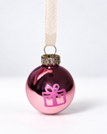 Handmade glossy pink glass Christmas ornament with pink gift box design and cream ribbon hanger