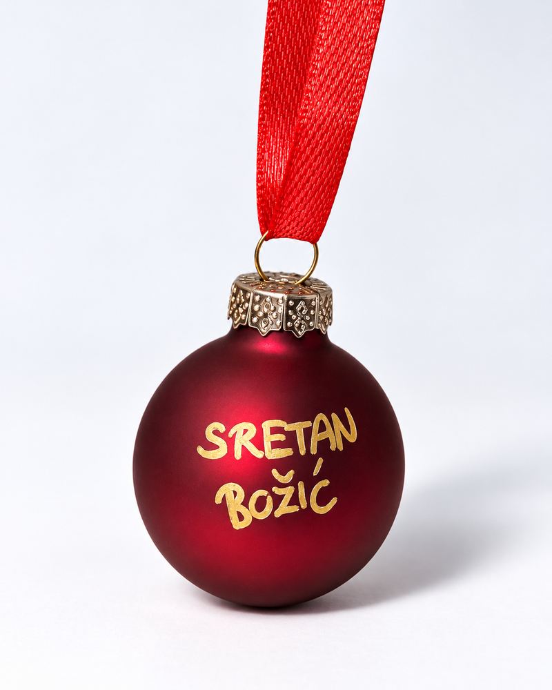 Handmade matte dark red glass Christmas ornament with gold Sretan Božić lettering and red ribbon hanger