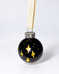 Handmade shiny black glass Christmas ornament with gold star design and white ribbon hanger