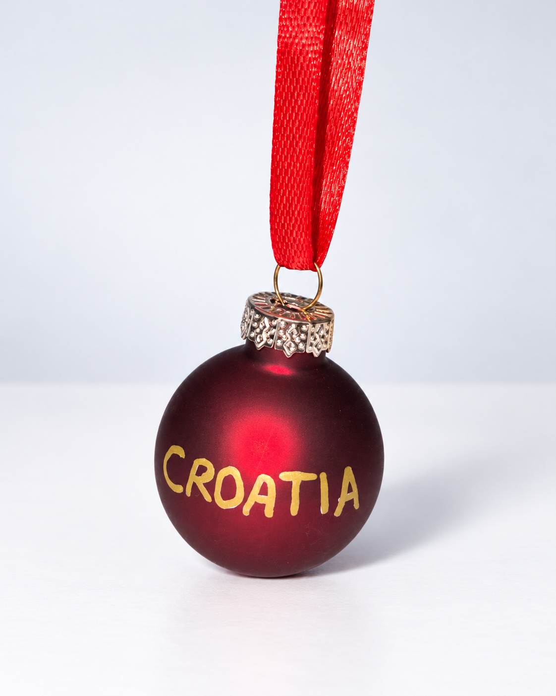Handmade dark red glass Christmas ornament with gold CROATIA lettering and red ribbon hanger