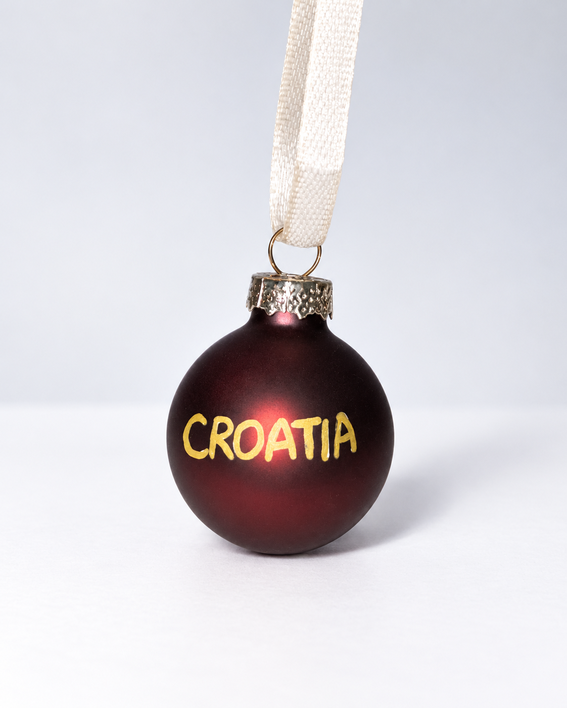 Handmade dark brown glass Christmas ornament with gold CROATIA lettering and white ribbon hanger